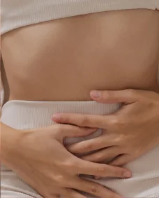 Mulher com as mãos sobre o abdômen