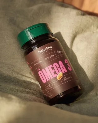 Frasco de Ômega 3 sobre um tecido em tons naturais
